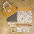 Kit "prêt à coudre" pour réaliser une housse avec anses pour tablette ou iPad en velours côtelé jaune doublée avec un tissu à motif léopard. Ce kit couture est composé de 2 plaques en mousse, de 2 pièces en velours côtelé jaune, de 5 pièces en coton imprimé à motif léopard, d'une fermeture éclair marron et de 2 sangles. La housse est personnalisable avec un prénom ou une inscription qui peut être floquée sur une étiquette en tissu coton et lin. En haut à gauche est présenté le produit fini.