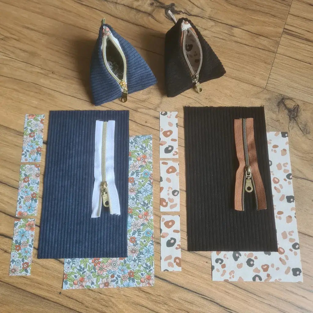 Kit "prêt à coudre" pour réaliser 2 trousses berlingots en velours côtelé doublées avec un tissu imprimé à motif. Les modèles présentés ici sont pour réaliser un berlingot en velours côtelé de coloris noir avec une doublure à motif léopard. La seconde trousse berlingot est en velours bleu foncé avec une doublure au motif fleurs. En bas, les pièces de tissus prédécoupées aux bonnes dimensions composant le kit. Au-dessus, les produits finis.