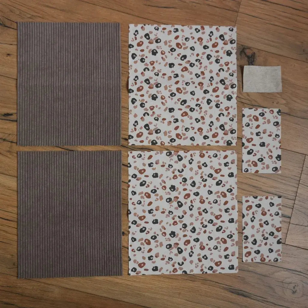 Kit prêt-à-coudre pour pochette à livre ou housse de liseuse composé de pièces de tissu en velours côtelé taupe et coton imprimé motif léopard, avec étiquette en lin assortie. Ensemble de coupons prédécoupés idéal pour un projet couture DIY pratique et élégant, parfait pour protéger un livre ou une tablette.