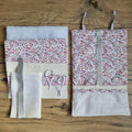 Kit "prêt-coudre" comprenant tous les éléments nécessaires pour confectionner une pochette de rangement multi-usages à rouler en nid d'abeille, molletonnée et doublée d'un tissu imprimé à motif. A gauche, toutes les pièces de tissus déjà prédécoupées pour réaliser l'ouvrage. A droite, la pochette déjà cousue. Le modèle présenté ici est en nid d'abeille de coloris naturel avec une doublure au motif liberty.