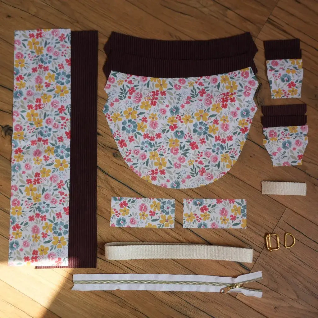 Kit prêt-à-coudre pour sac banane demi-lune composé de pièces de tissu en coton fleuri motif Bridget et velours côtelé prune, sangle beige, fermoirs métalliques et fermeture éclair dorée inclus, idéal pour un projet couture DIY tendance et pratique. Ensemble de coupons prédécoupés pour fabriquer un sac banane fait main.
