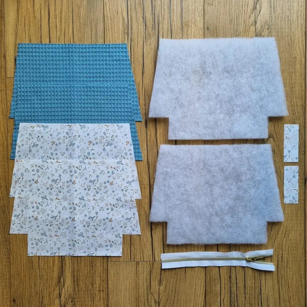Kit prêt-à-coudre pour trousse zippée en tissu nid d’abeille bleu denim et coton imprimé fleuri, avec doublure, molleton, fermeture éclair blanche et pièces assorties prédécoupées. Parfait pour projet couture DIY ou cadeau fait main.