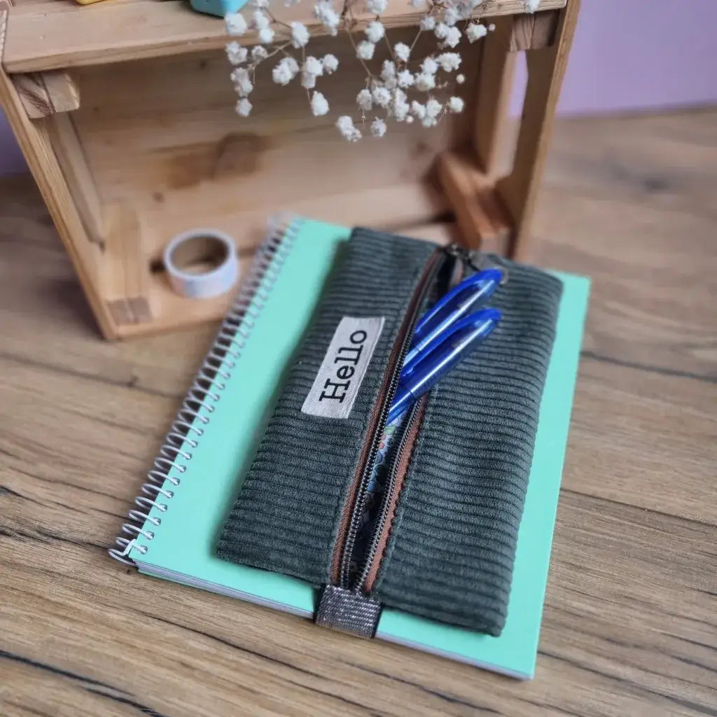 Trousse élastique personnalisée en velours côtelé vert avec fermeture zippée centrale – accessoire pour carnet A5, pratique pour ranger stylos et fournitures scolaires.