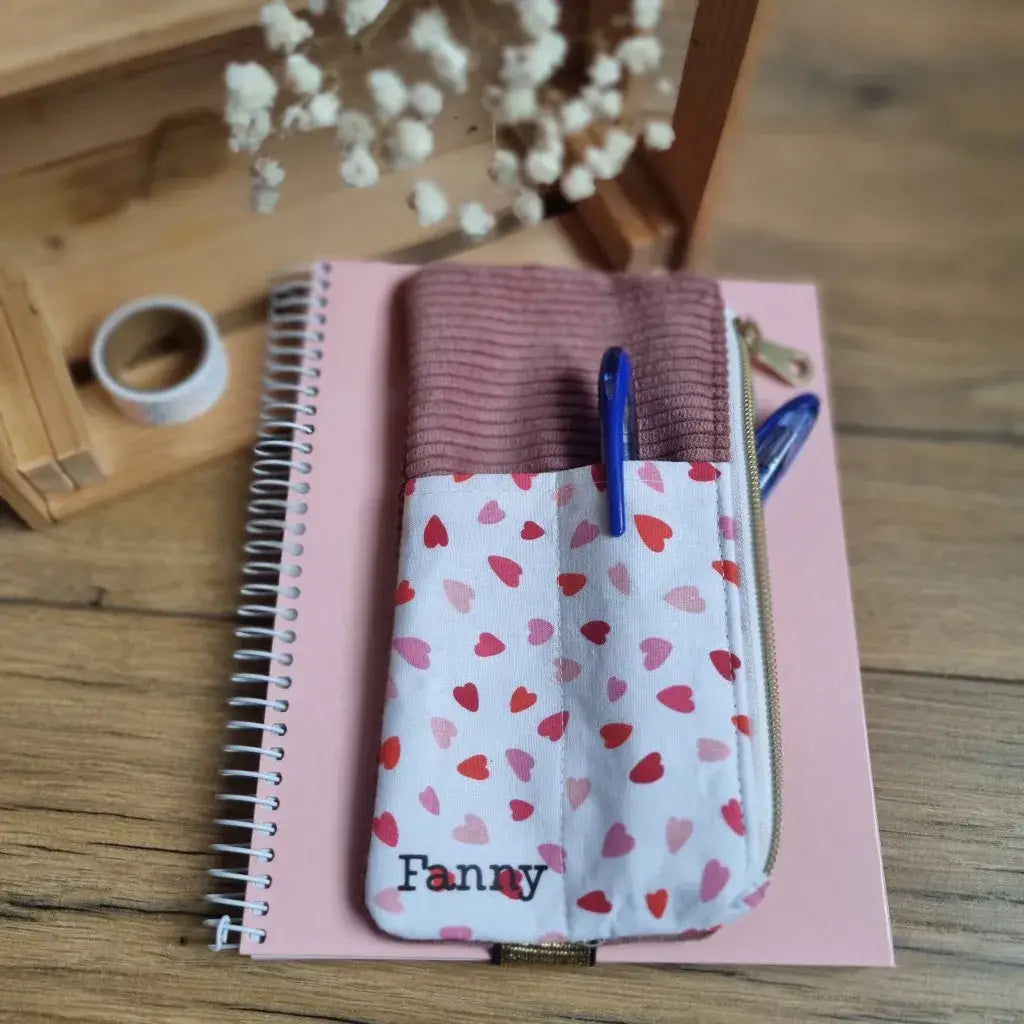 Trousse élastique personnalisée pour carnet A5 en velours rose et tissu à motifs cœurs, avec fermeture éclair latérale – modèle prénom ‘Fanny’, idéal pour stylos et accessoires scolaires.