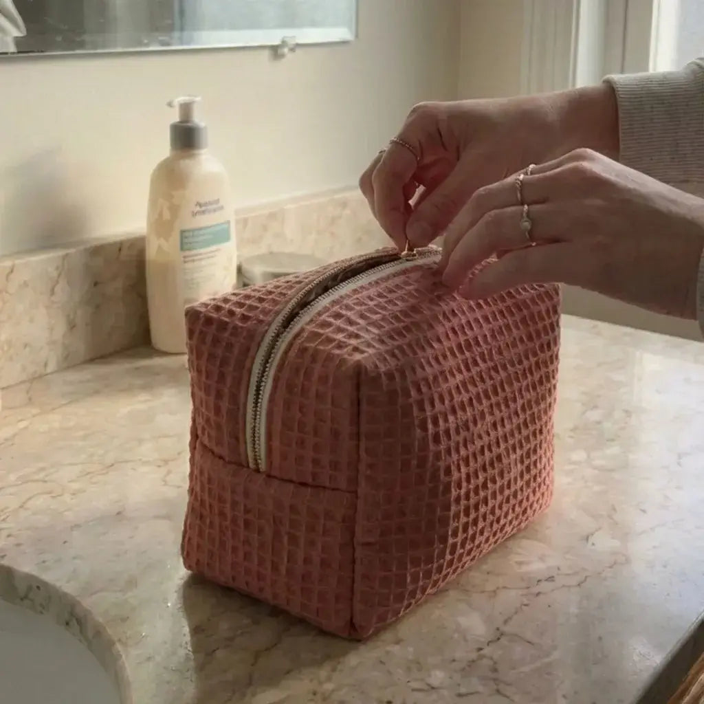 trousse maquillage marsala nid d’abeille fermée avec zip posée sur plan de salle de bain