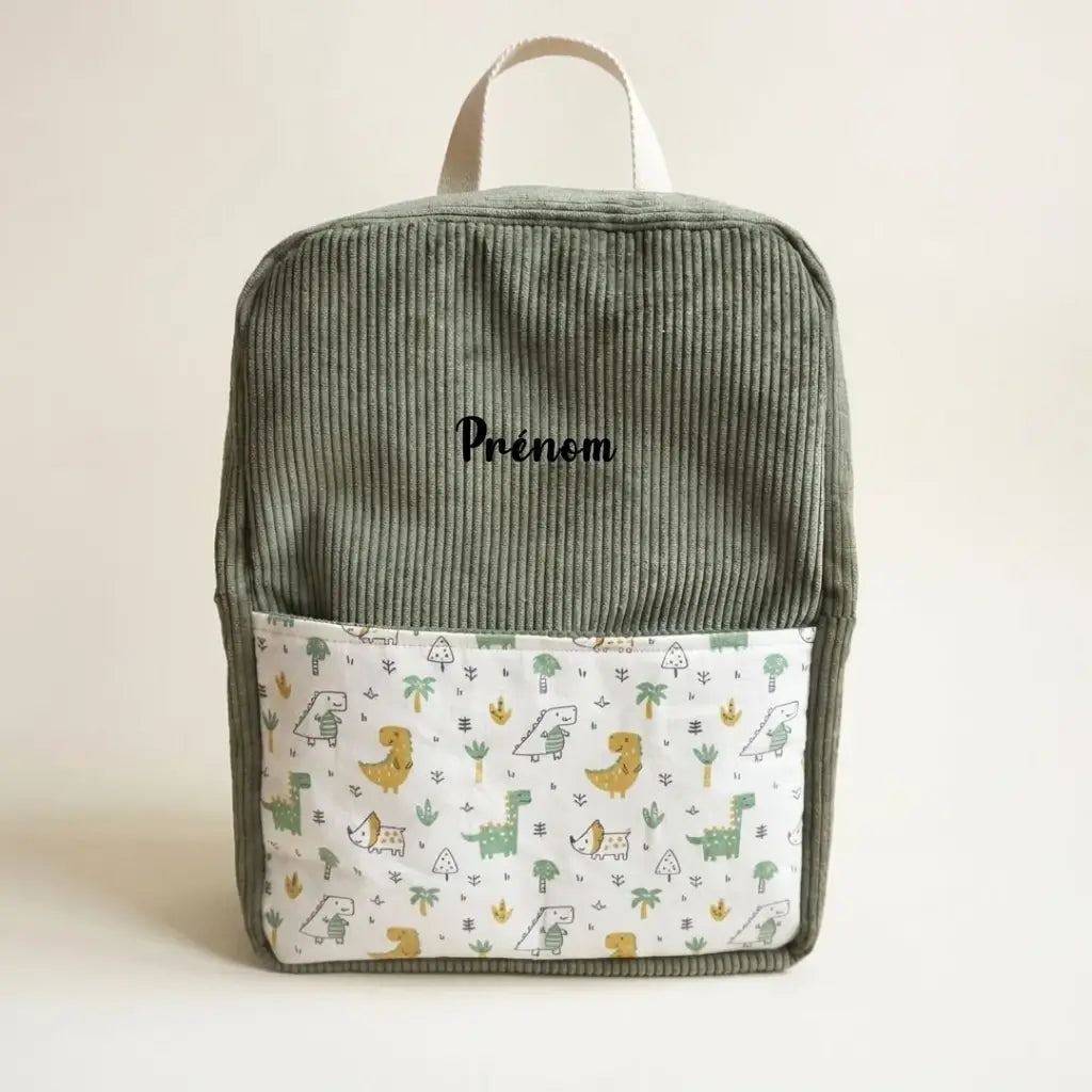 Sac à dos enfant vert en velours côtelé, poche à motif dinosaures et prénom sur le devant