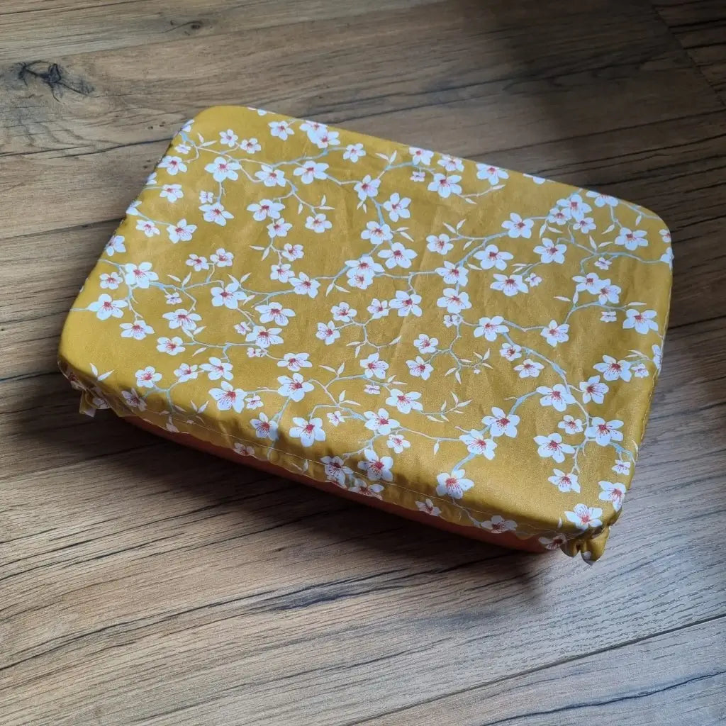 Charlotte couvre-plat de forme rectangulaire en coton enduit réutilisable au motif fleurs jaunes. Cette charlotte alimentaire est étirée sur un plat rectangulaire idéalement de dimensions 34x24 cm mais pouvant aller jusqu'à 36x26 cm.