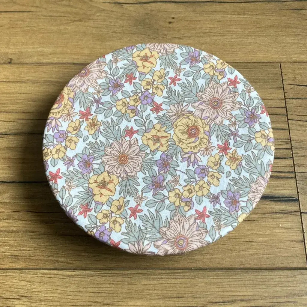 Charlotte couvre-plat rond en coton enduit réutilisable au motif fleurs mauves. Cette charlotte alimentaire est étirée sur un bol ou une assiette creuse pouvant aller d'un diamètre de 20 à 22 cm. 