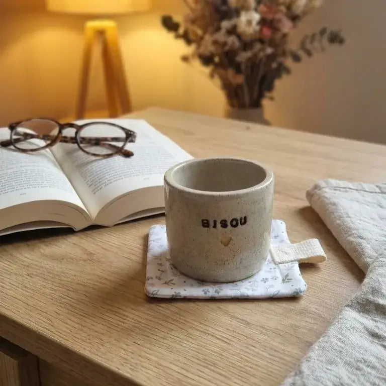 dessous de tasse molletonné isolant en tissu fleuri avec mug sur bureau en bois
