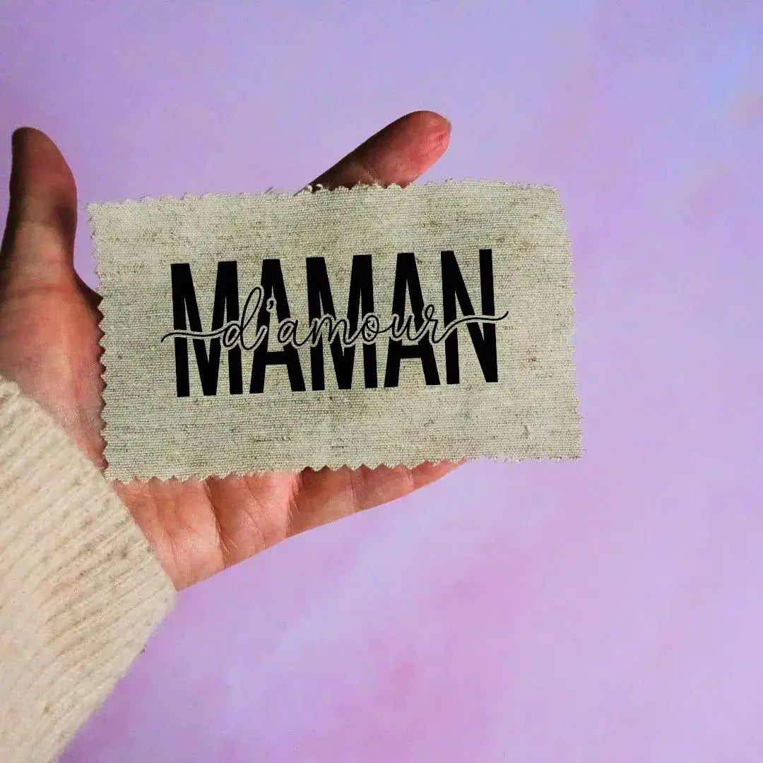 étiquette à coudre maman d’amour typographie noire superposée sur fond beige