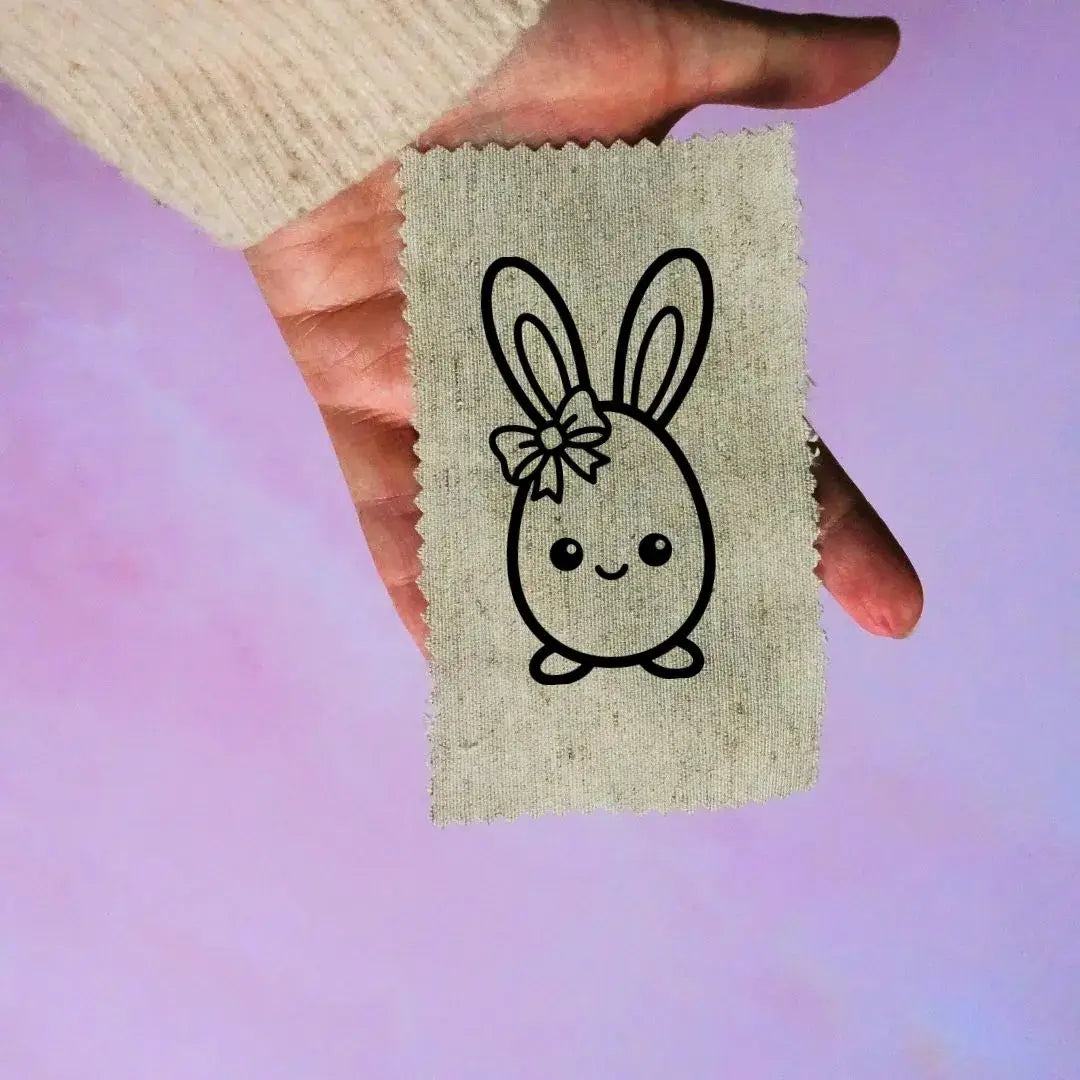 étiquette tissu Pâques motif lapin sortant œuf noir sur tissu beige accessoire couture enfant