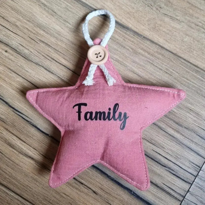 Etoile en tissu double gaze de coton de coloris marsala. Cette étoile peut se suspendre à l'aide d'une petite cordelette en coton maintenue avec un ravissant petit bouton. Cette étoile est personnalisée avec l'inscription "Family" floquée à l'écriture noire en son centre.