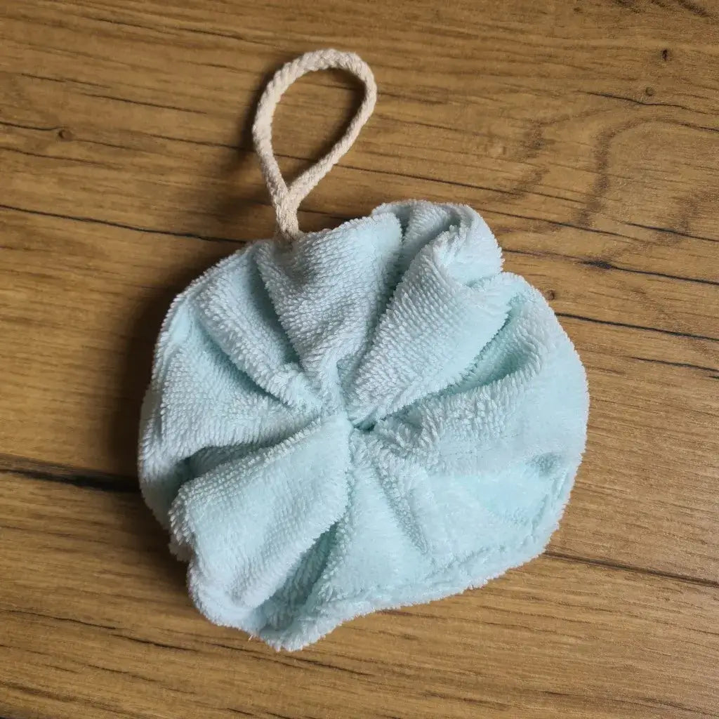 Fleur de douche lavable en éponge de bambou de coloris celadon. Cette fleur de douche est dotée d'un petit cordon en coton lui permettant d'être suspendue à la douche.