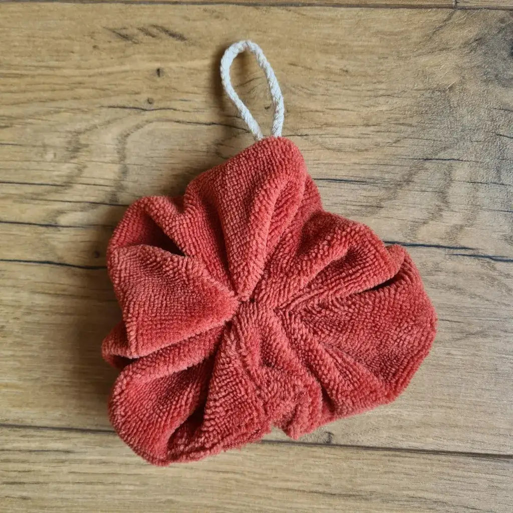 Fleur de douche lavable en éponge de bambou de coloris terracotta. Cette fleur de douche est dotée d'un petit cordon en coton lui permettant d'être suspendue à la douche.