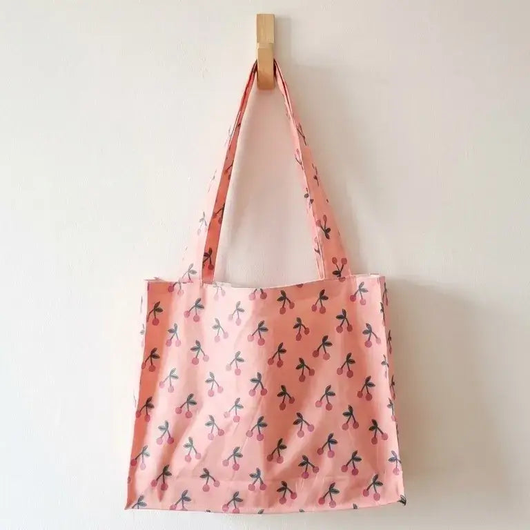 grand sac de plage coton enduit rose motif cerises suspendu avec anses longues et format cabas