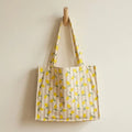 sac de plage coton enduit motif citron posé en terrasse avec grande contenance et anses épaules