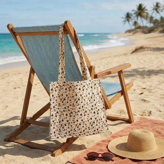 sac de plage imperméable coton enduit motif léopard posé sur sable avec chaise longue et chapeau