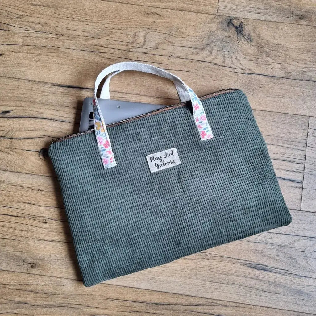 Housse d’ordinateur portable en velours côtelé vert avec poignées en sangle imprimée fleurie, fermeture éclair et étiquette personnalisée, idéale pour transporter un laptop avec style et protection. Pochette ordinateur faite main, pratique pour le bureau, les cours ou les déplacements.