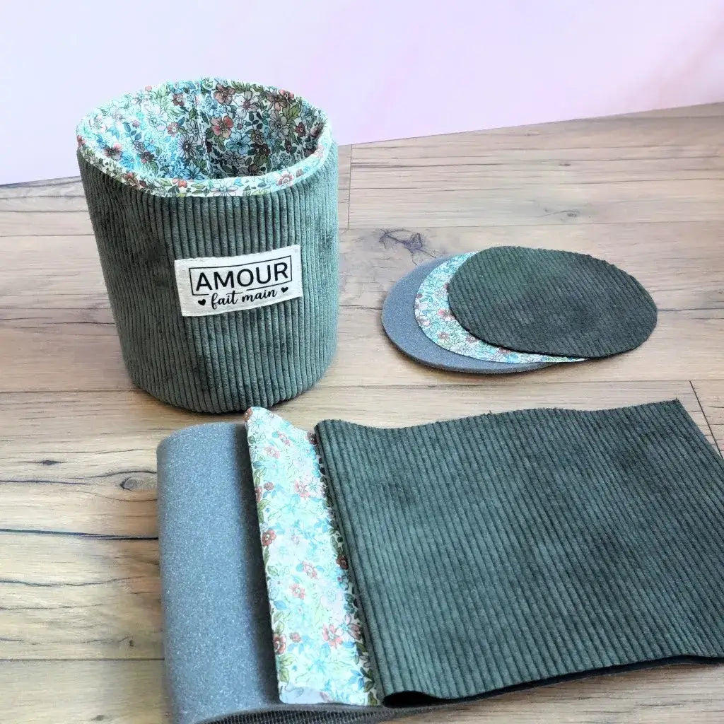 Panier couture fini avec étiquette Amour fait main, velours vert sauge et doublure fleurie sur parquet.