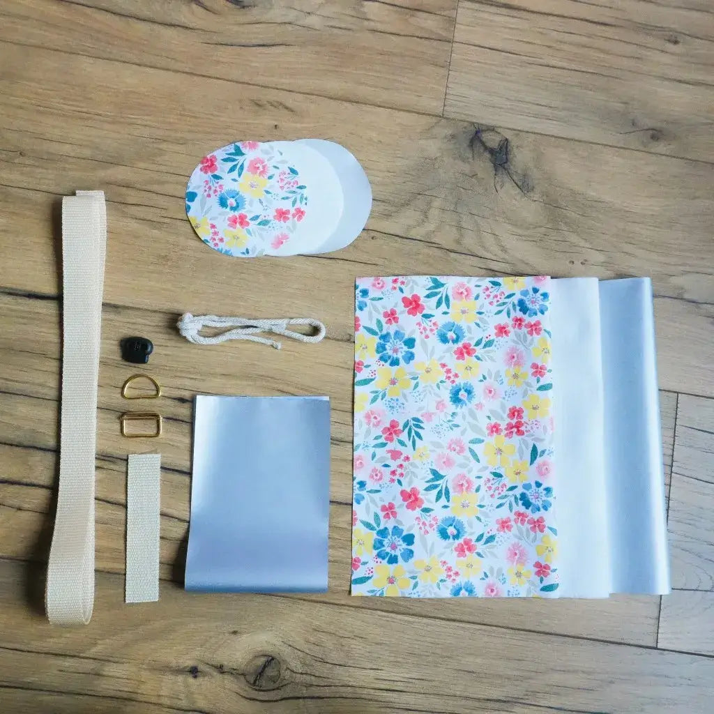 Kit couture complet porte-gourde motif Bridget : coton enduit floral, isolant thermique, sangle beige et cordon blanc.