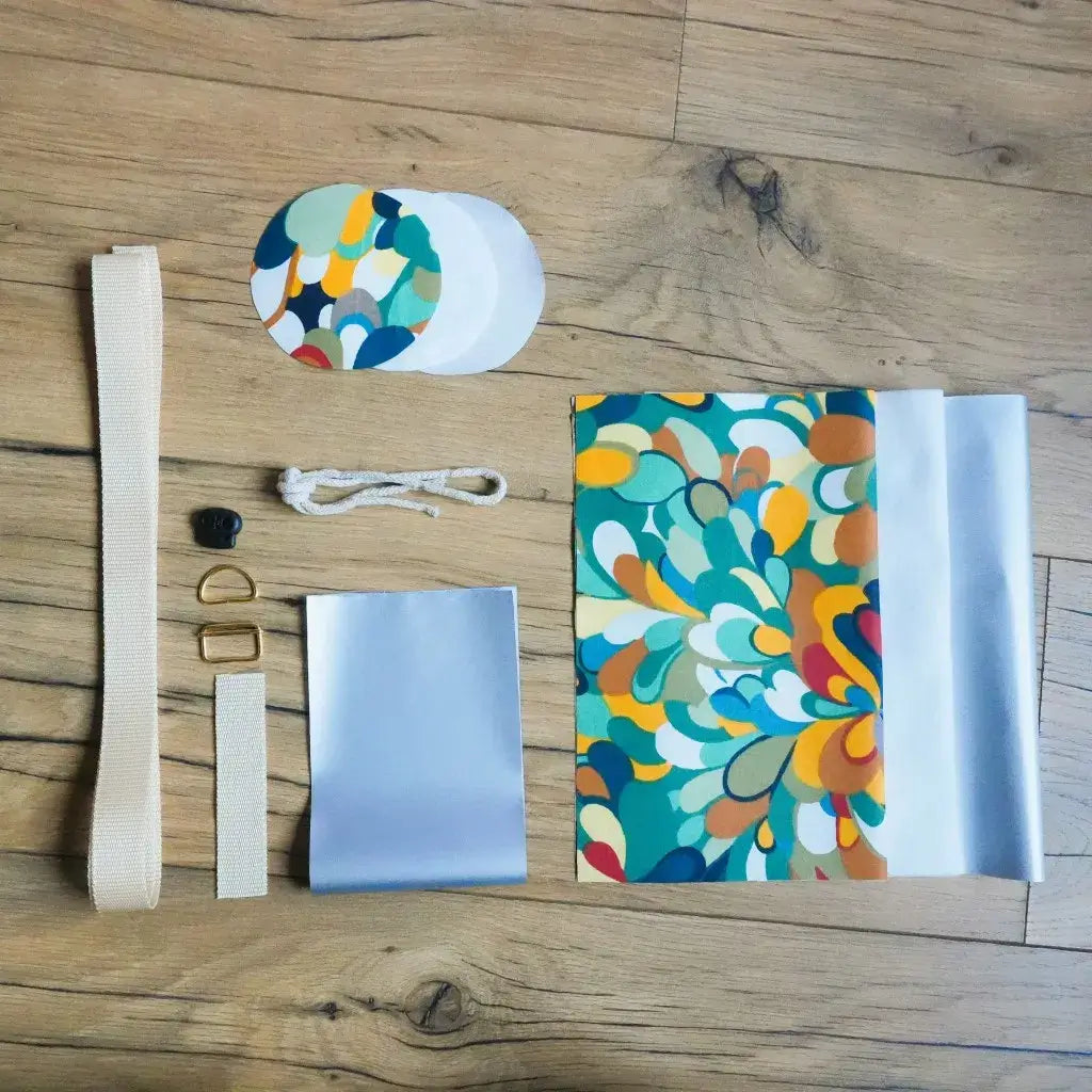 Kit couture complet pour porte-gourde au motif Splash : coupons de coton enduit aux formes abstraites, isolant, sangle beige et mercerie.