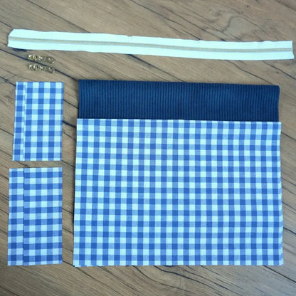 Kit couture prêt-à-coudre pour créer une trousse carrée en tissu vichy bleu et blanc, associée à un empiècement en velours côtelé bleu marine. Le lot comprend également une fermeture éclair écrue et deux curseurs métalliques dorés. Facile à assembler, ce kit DIY permet de réaliser une trousse artisanale au style classique et intemporel, idéale pour le rangement ou comme idée cadeau personnalisée.
