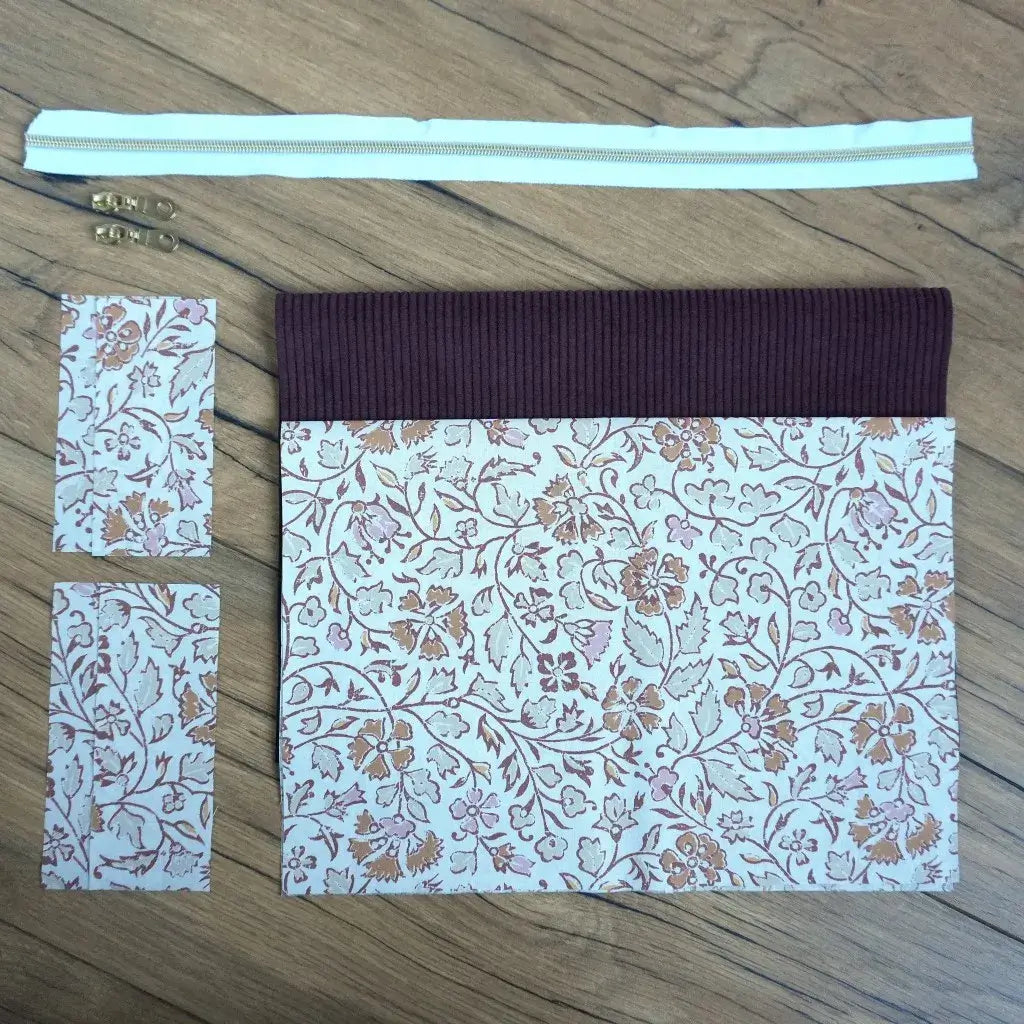 Kit couture prêt-à-coudre pour créer une trousse carrée raffinée, associant un velours côtelé prune à un tissu fleuri beige et terracotta aux motifs délicats. Fournie avec une fermeture éclair blanche et deux curseurs dorés, cette trousse DIY allie élégance et praticité. Un projet accessible et décoratif, idéal pour offrir ou personnaliser son rangement avec une touche artisanale et chaleureuse.