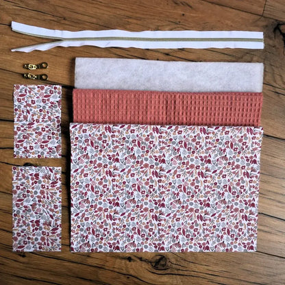 Kit couture DIY pour confectionner une trousse carrée en nid d’abeille coloris marsala, assortie à une doublure en coton fleuri type liberty. Contient tous les éléments nécessaires : tissus découpés, ouate, fermeture éclair dorée et curseurs métalliques. Un projet de couture accessible et élégant pour créer une trousse personnalisée, idéale pour offrir ou pour organiser ses accessoires du quotidien.