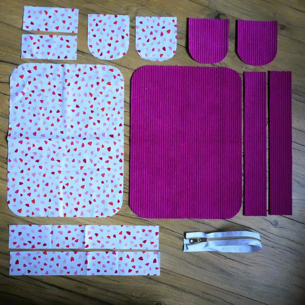 Kit couture : velours côtelé magenta et tissu à petits cœurs avec zip blanc, le tout prêt à être assemblé.