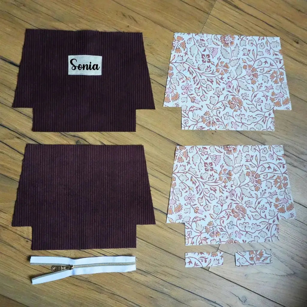 Kit couture trousse prune : velours mauve foncé, doublure fleurie orientale, zip blanc et étiquette Sonia sur bois.