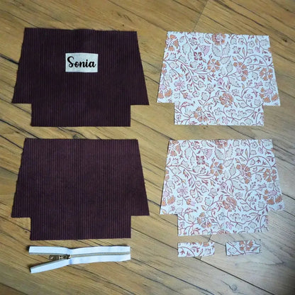 Kit couture trousse prune : velours mauve foncé, doublure fleurie orientale, zip blanc et étiquette Sonia sur bois.