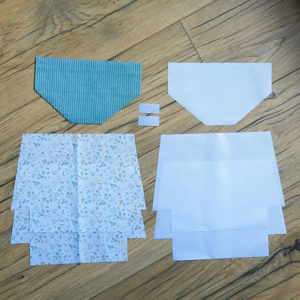 Kit couture DIY pour confectionner une pochette à scratch imperméable, comprenant un rabat en velours côtelé bleu clair, plusieurs coupons de coton blanc imprimé de petites fleurs délicates, doublures blanches en coton enduit et bandes de scratch. Tous les éléments sont prêts à assembler, idéal pour créer une trousse personnalisée pratique, élégante et facile à coudre, même pour les débutants.