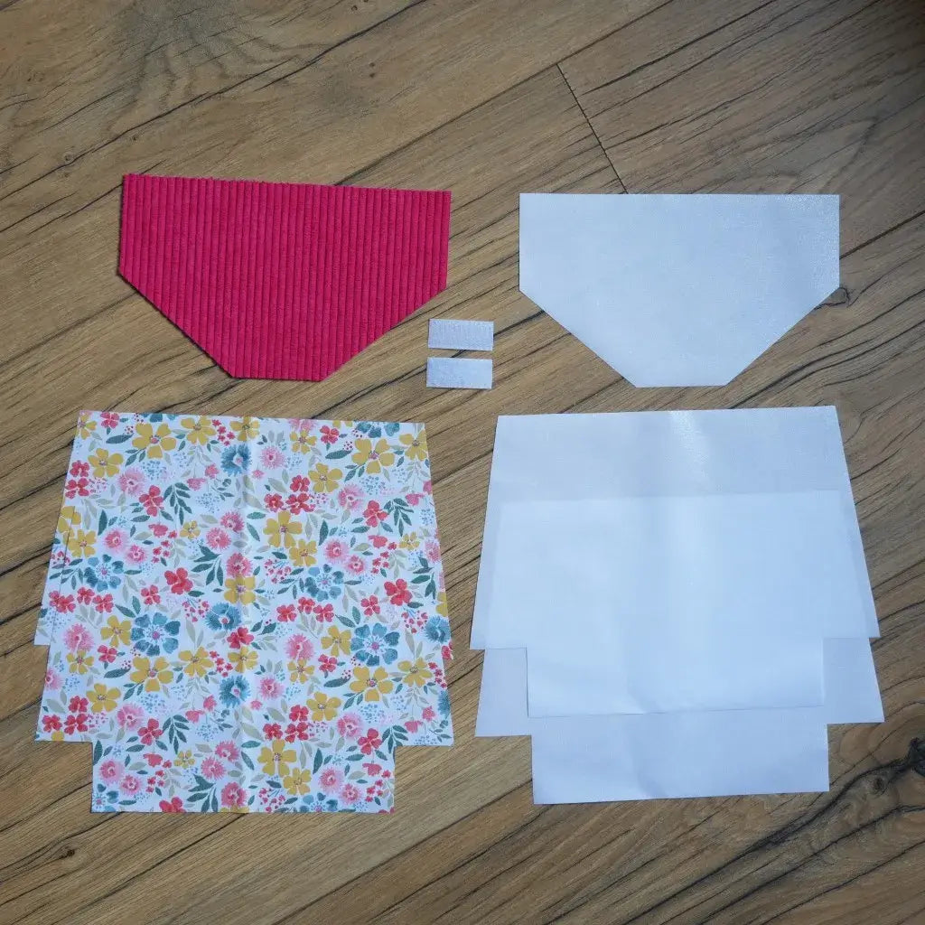 Kit couture créatif pour réaliser une pochette à scratch imperméable, comprenant un rabat en velours côtelé framboise, des coupons de coton imprimé de fleurs colorées aux tons jaunes, rouges et bleus, des doublures blanches en coton enduit ainsi que des bandes de scratch. Un ensemble idéal pour coudre une trousse unique, pratique et résistante, parfaite pour un cadeau personnalisé ou un projet DIY rapide.