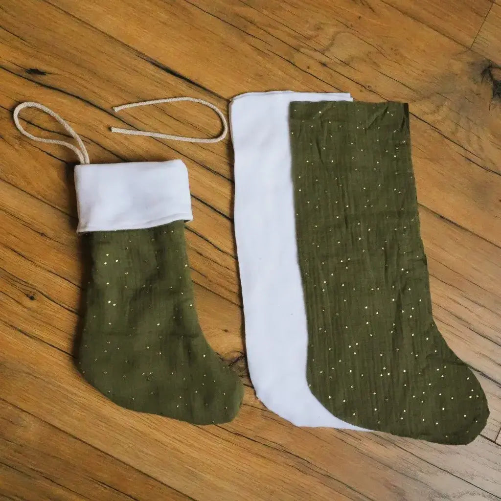 Kit prêt-à-coudre pour confectionner une botte de Noël vert sapin en double gaze de coton parsemée de fines touches dorées. Le kit inclut la doublure blanche et le cordon pour l’accrocher. Projet DIY simple et festif pour une décoration naturelle et élégante. Idéal à personnaliser avec un prénom pour une création unique, faite main et éco-responsable, à suspendre au coin du feu ou sous le sapin.