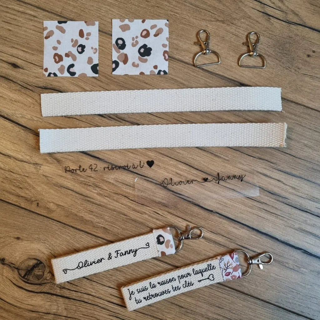 Kit prêt-à-coudre pour réaliser un duo de porte-clés avec inscription personnalisée. Le kit comprend 6 pièces et 2 inscriptions à floquer. En-dessous sont présentés les deux porte-clés finalisés.
