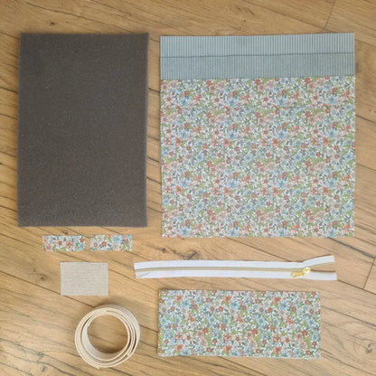Kit "prêt à coudre" pour réaliser une housse avec anses pour tablette ou iPad en velours côtelé bleu clair doublée avec un tissu à motif fleurs. Ce kit couture est composé de 2 plaques en mousse, de 2 pièces en velours côtelé bleu clair, de 5 pièces en coton imprimé à motif fleurs, d'une fermeture éclair blanche et de 2 sangles. La housse est personnalisable avec un prénom ou une inscription qui peut être floquée sur une étiquette en tissu coton et lin.