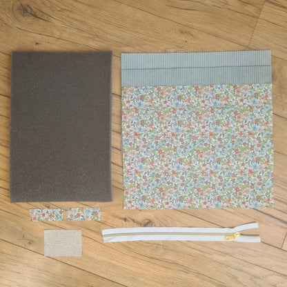 Kit "prêt à coudre" pour réaliser une housse pour tablette ou iPad en velours côtelé bleu clair doublée avec un tissu à motif fleurs. Ce kit couture est composé de 2 plaques en mousse, de 2 pièces en velours côtelé bleu clair, de 5 pièces en coton imprimé à motif fleurs et d'une fermeture éclair blanche. La housse est personnalisable avec un prénom ou une inscription qui peut être floquée sur une étiquette en tissu coton et lin.
