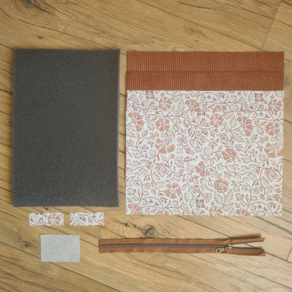 Kit "prêt à coudre" pour réaliser une housse pour tablette ou iPad en velours côtelé marron doublée avec un tissu à motif oriental. Ce kit couture est composé de 2 plaques en mousse, de 2 pièces en velours côtelé marron, de 5 pièces en coton imprimé à motif oriental et d'une fermeture éclair marron. La housse est personnalisable avec un prénom ou une inscription qui peut être floquée sur une étiquette en tissu coton et lin.