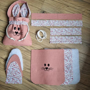 Kit prêt-à-coudre pour réaliser un panier de Pâques molletonné en tissu nid d'abeille avec anse. Le modèle présenté ici est de coloris marsala avec une doublure au motif liberty. En haut à gauche est présenté le produit fini. Tout autour de celui-ci sont disposés l'ensemble des pièces nécessaires composant le kit pour la réalisation de cette création.