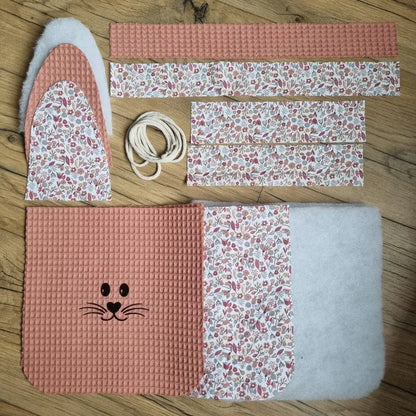 Kit prêt-à-coudre pour réaliser un panier de Pâques molletonné en tissu nid d'abeille marsala avec anse. Ce kit est composé de 5 pièces en tissu nid d'abeille, 7 pièces en coton imprimé à motif (ici est présenté le motif liberty), 4 pièces en molleton et de cordelette. Ce kit est personnalisable avec le flocage d'un prénom en option.