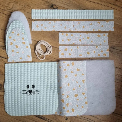 Kit prêt-à-coudre pour réaliser un panier de Pâques molletonné en tissu nid d'abeille menthe avec anse. Ce kit est composé de 5 pièces en tissu nid d'abeille, 7 pièces en coton imprimé à motif (ici est présenté le motif argeo), 4 pièces en molleton et de cordelette. Ce kit est personnalisable avec le flocage d'un prénom en option.