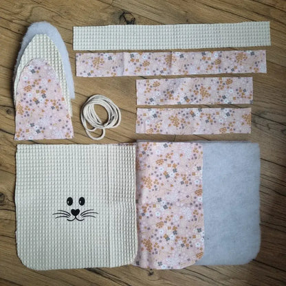 Kit prêt-à-coudre pour réaliser un panier de Pâques molletonné en tissu nid d'abeille naturel avec anse. Ce kit est composé de 5 pièces en tissu nid d'abeille, 7 pièces en coton imprimé à motif (ici est présenté le motif bouquet), 4 pièces en molleton et de cordelette. Ce kit est personnalisable avec le flocage d'un prénom en option.