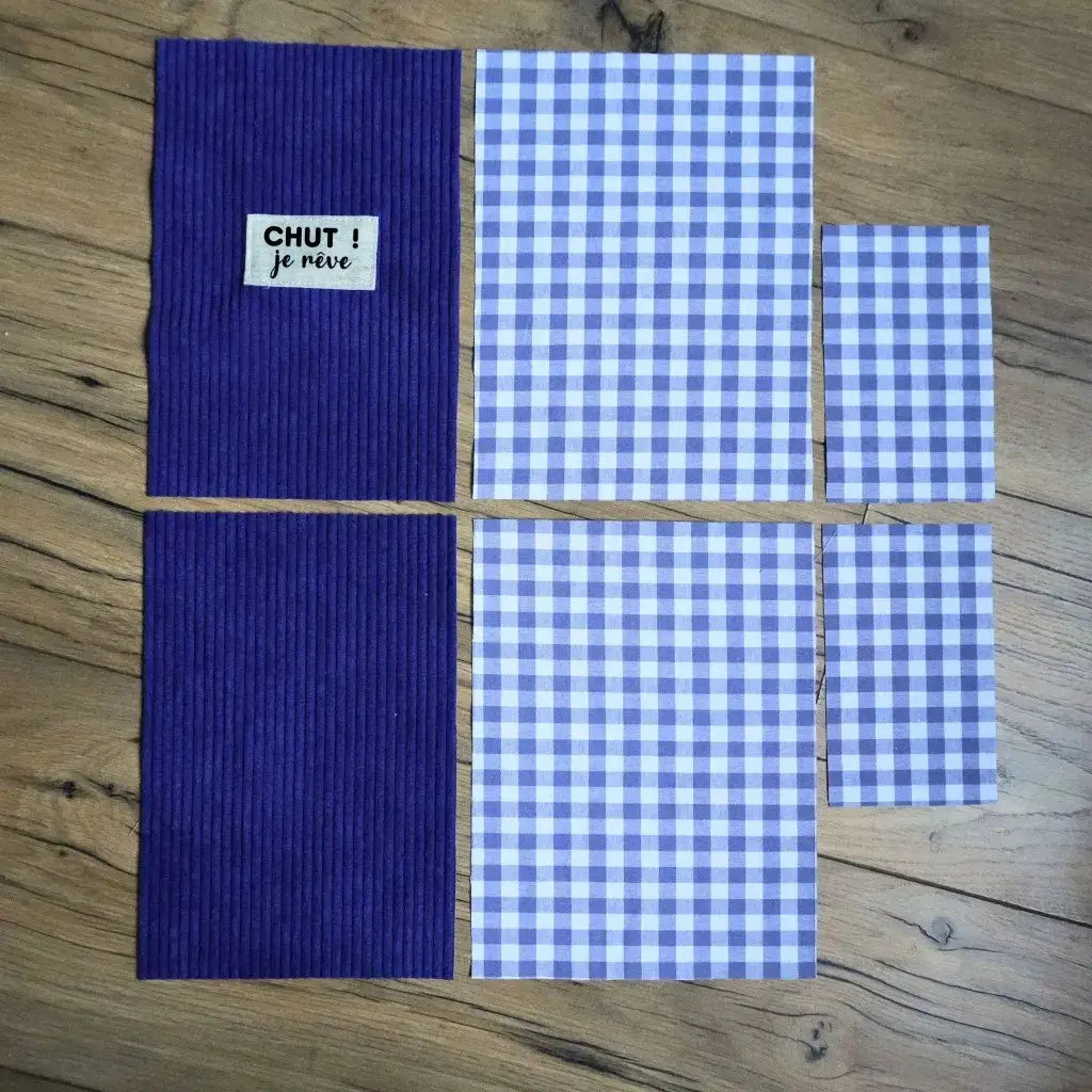 Kit couture : pièces de velours bleu et tissu vichy assorti posées à plat sur un parquet en bois.