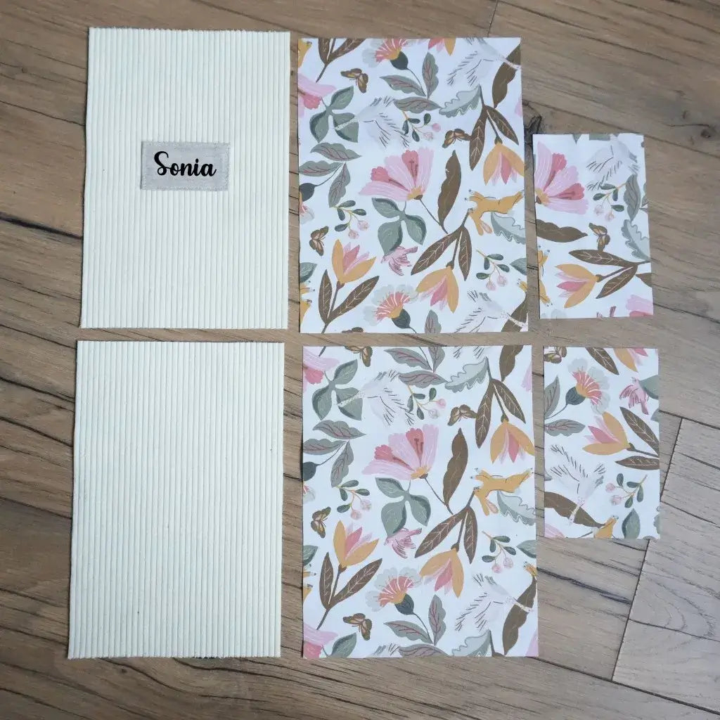 Kit couture personnalisé : pièces de velours côtelé jaune pâle et tissu floral posées sur un parquet en bois.