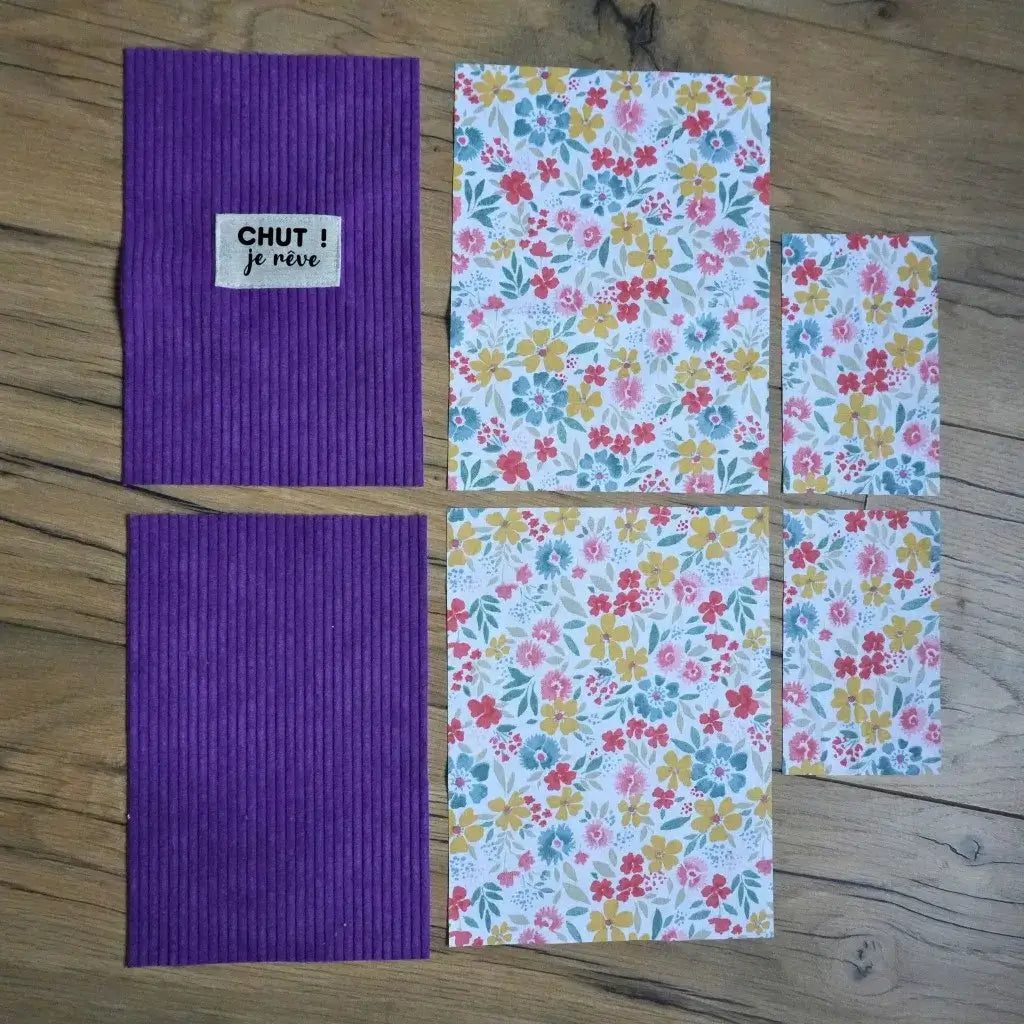 Kit couture avec étiquette personnalisée : velours côtelé lavande et tissu fleuri coloré disposés sur un sol en bois.