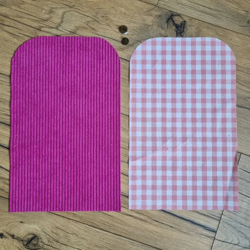 Kit couture prêt-à-coudre pour confectionner une pochette aimantée en velours côtelé magenta et coton à carreaux roses. Ensemble comprenant les tissus découpés et les boutons magnétiques pour un projet DIY accessible et tendance. Idéal pour couturières débutantes souhaitant créer un accessoire élégant et fait main aux finitions soignées.