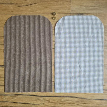 Kit "prêt à coudre" pour une pochette aimantée en velours côtelé au coloris taupe avec une doublure en tissu à motif carreaux beiges. L'ensemble des pièces de tissu, déjà prédécoupées aux bonnes dimensions, sont disposées au sol. A gauche, une pièce en velours côtelé taupe. A droite, une pièce en tissu imprimé à motif carreaux beiges. Entre les deux, les 2 pièces composant un bouton aimanté.