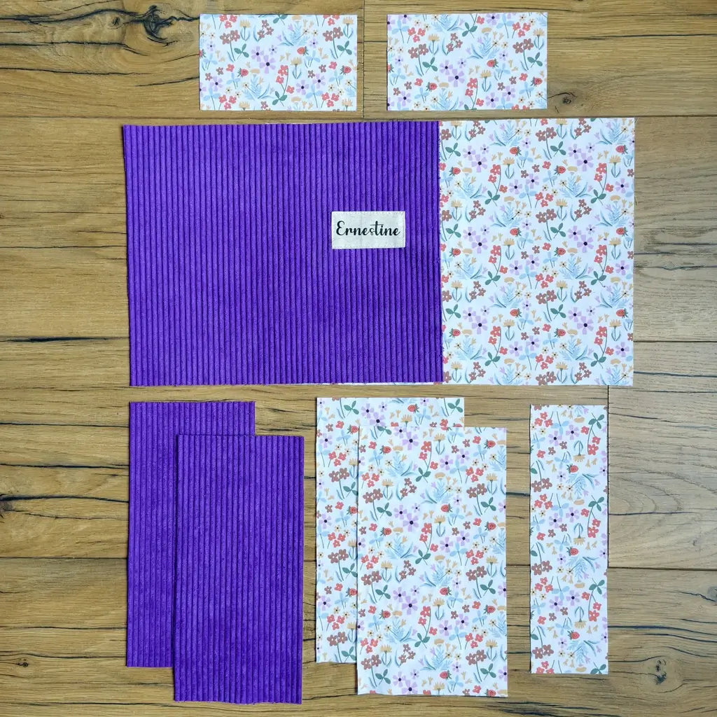 Pièces de tissu découpées en velours côtelé violet et coton fleuri, étiquette au prénom Ernestine
