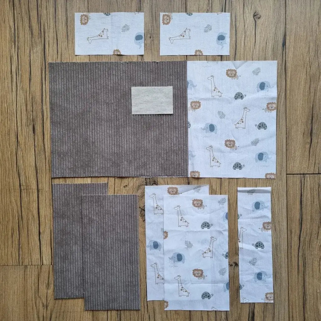 Kit prêt-à-coudre pour protège carnet de santé, composé de tissus prédécoupés en velours côtelé taupe et d’un imprimé savane avec girafes, lions, tortues et éléphants. Accessoire DIY idéal pour confectionner un protège carnet unique et personnalisé. Motif doux et naturel inspiré des animaux de la savane, parfait pour un cadeau de naissance ou pour organiser le carnet de bébé avec une touche originale. Kit complet avec toutes les pièces nécessaires pour une couture facile et un rendu soigné.