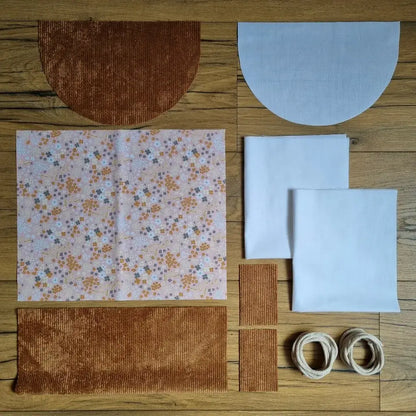 Kit couture débutant pour sac à dos pochon avec rabat en velours marron : tissu extérieur à motif fleuri pastel "bouquet", doublure unie blanche et cordons écrus. Parfait pour projet DIY. 